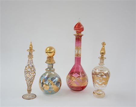 Lotto composto da quattro bottiglie diverse in vetro decorate a dorature...