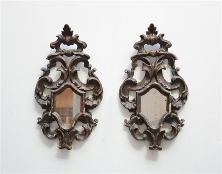 Coppia di specchierine in legno intagliato e argentato a volute (cm 76x34)...