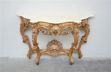 Consolle di forma mossa in legno dorato decorato a valve di conchiglia e...