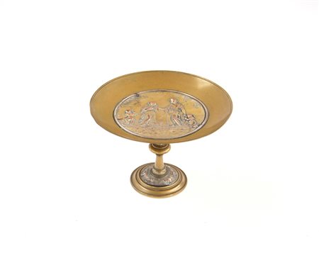 Alzata in bronzo dorato decorata nel cavetto in rame sbalzato a scena...