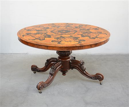 Tavolo da pranzo di forma tonda con piano lastronato in noce ed intarsiato in...