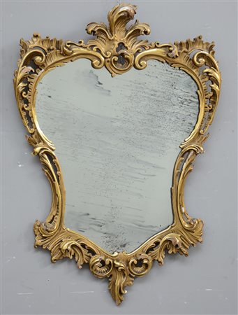 Specchiera con cornice di gusto rocaille in legno intagliato e dorato, sec....