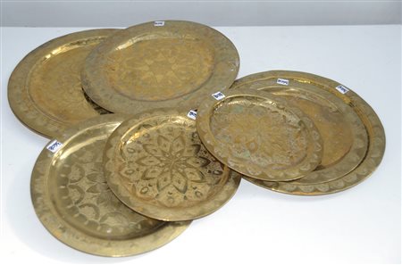 Gruppo di otto piatti in ottone decorati a motivi orientali stilizzati...