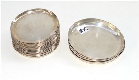 Gruppo di diciannove sottobicchieri e quattro sottobottiglie in metallo...