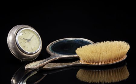 Lotto composto da uno specchio a mano, una spazzola e un orologio da tavolo...