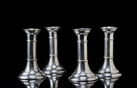 Gruppo di quattro candelieri in metallo argentato a corpo liscio (h. cm 15)...