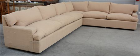 Divano ad angolo a sei posti rivestito in tessuto beige munito di rotelle....