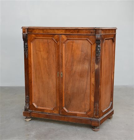 Credenza di forma sagomata in noce con fronte a due ante e montanti...