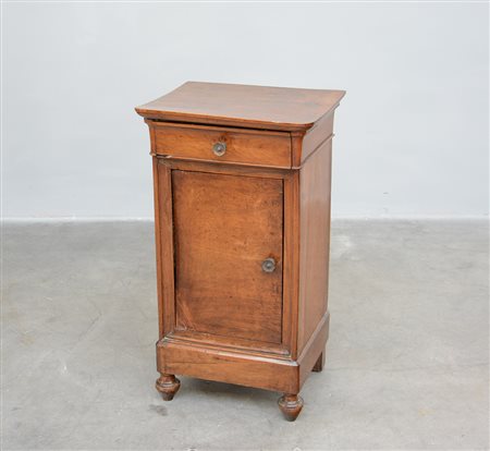 Comodino in noce ad un'anta e un cassetto con piedi torniti. Sec. XIX (cm...