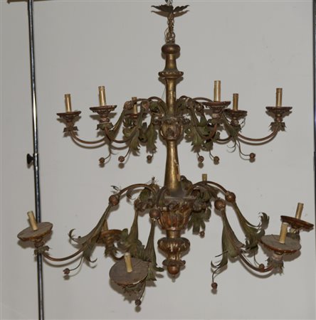 Lampadario a dodici fiamme in legno intagliato a motivi vegetali, braccia in...