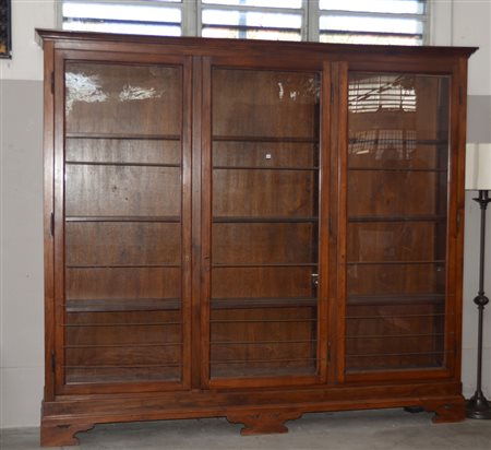 Mobile libreria a tre ante a vetri decorate con elementi in metallo. Piedi a...