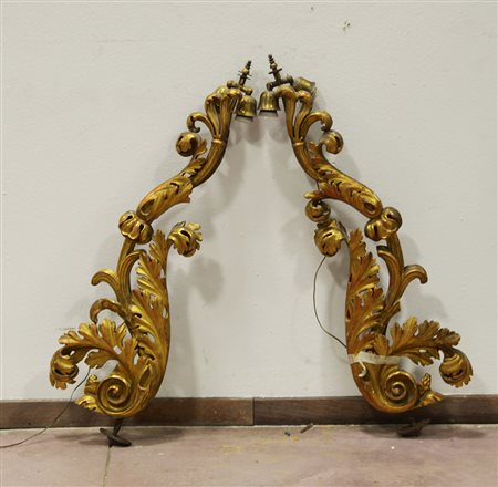 Coppia di fregi di forma sagomata in legno dorato ed intagliato a volute...