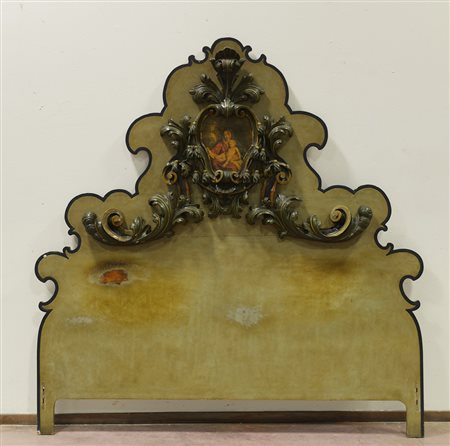 Letto con testata di forma sagomata decorato da fregio in legno intagliato e...