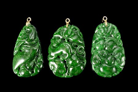 Tre intagli in giadeite color verde acceso, raffiguranti frutti e creature...