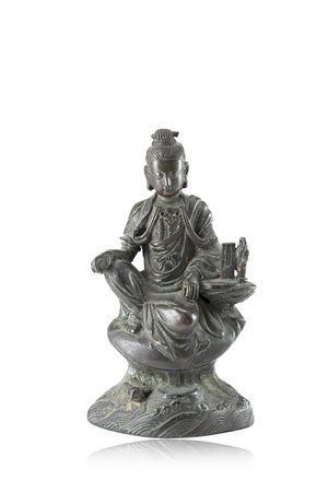 Guanyin in bronzo seduta su trono in roccia, i capelli raccolti, indossa...