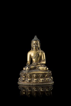 Buddha in bronzo dorato, raffigurato seduto in dhyanasana su base a doppio...