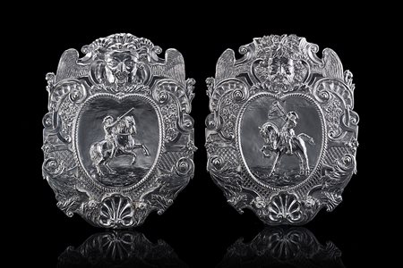 Coppia di appliques in argento con sbalzo centrale raffigurante cavalieri...