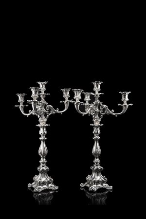 Coppia di candelabri in argento a quattro fiamme con corpo a sezione quadrata...