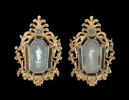 Coppia di antiche specchiere in legno intagliato e dorato a volute, fiori,...