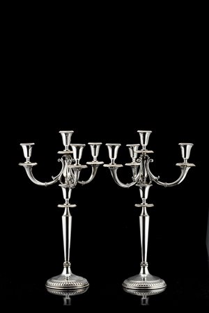 Coppia di candelabri in argento a quattro fiamme, piede circolare baccellato,...
