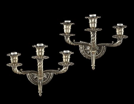 Coppia di appliques in argento a tre fiamme decorate con bracci sagomati a...