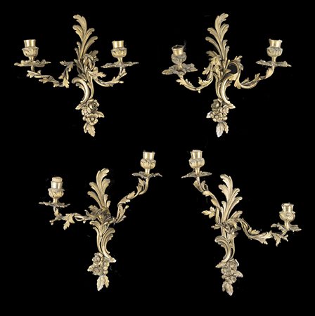 Gruppo di quattro appliques a due fiamme in bronzo decorato a foglie e fiori...