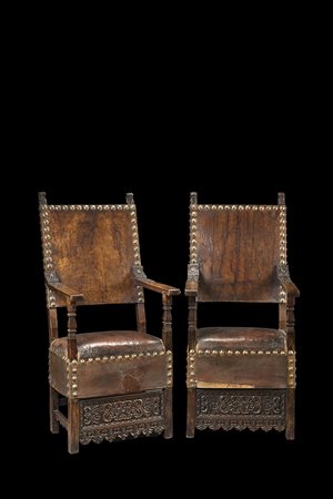Coppia di seggioloni in noce con puntali intagliati a teste leonine. Gambe...