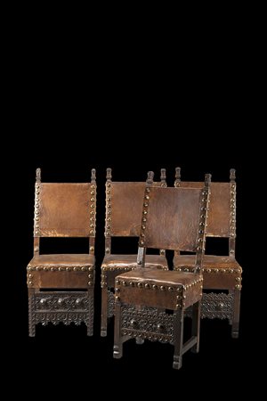 Gruppo di quattro sedie diverse in noce con puntali intagliati a motivi...