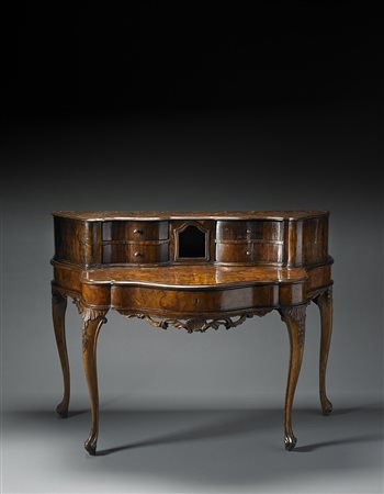 Scrivania di forma mossa in noce e radica, piano con alzata a quattro...