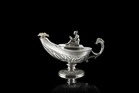 Piccola lucerna in argento decorata con fasce di foglie lanceolate, cimatura...