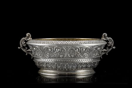 Centrotavola in argento di forma ovale modanata, decorato con foglie d'acanto...