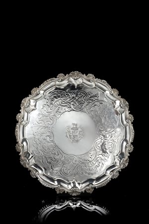 Salver in argento con fondo decorato a motivi floreali e stemma incisi....