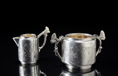 Zuccheriera e lattiera in argento inciso e cesellato. Anse con farfalla....