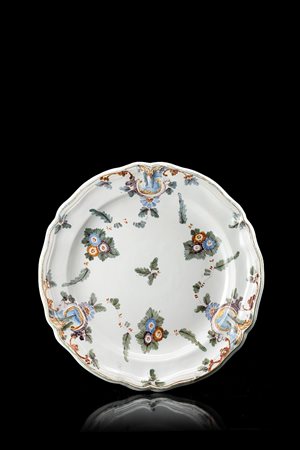 Piatto tondo in maiolica con orlo rialzato e polilobato. Tesa leggermente...
