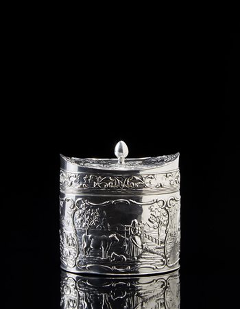 Scatola porta tè in argento di forma ovale con coperchio e corpo sbalzato a...