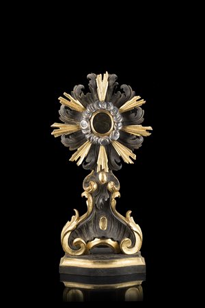 Reliquiario in legno intagliato e dorato a motivi fogliati, volute e...