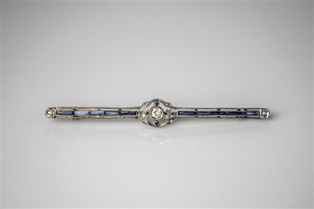 Spilla art decò in oro bianco, gr 3.70. Zaffiri baguette e brillanti cts...