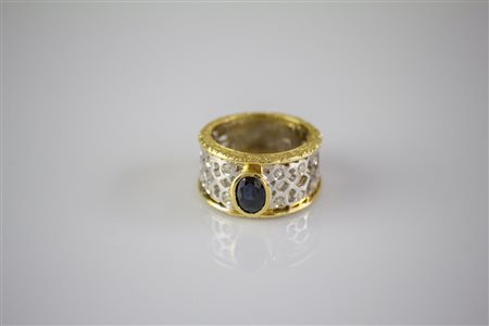 Anello in oro bianco e giallo 18kt, gr 8.10. Diamanti cts 0.14. Zaffiro...