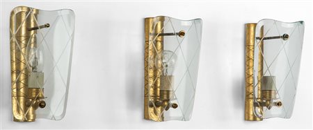 TRE LAMPADE A PARETE, anni '40. Ottone, cristallo inciso curvato e molato....
