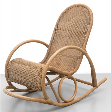 UNA POLTRONA A DONDOLO, anni '60. Malacca, midollino. Altezza cm 97,...