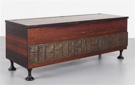 UNA CASSAPANCA, anni '60. Legno di palissandro tornito tinto all'anilina,...