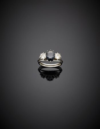 Anello in oro bianco con zaffiro ovale e due diamanti ai lati per complessivi...