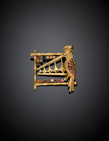 Spilla in oro giallo lucido e satinato con pappagallo e strumento musicale...