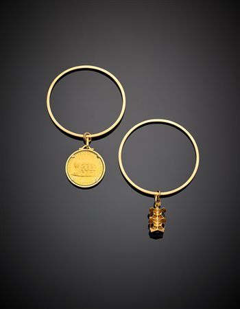 Due bracciali rigidi a cerchio a sezione squadrata e due charms con moneta e...