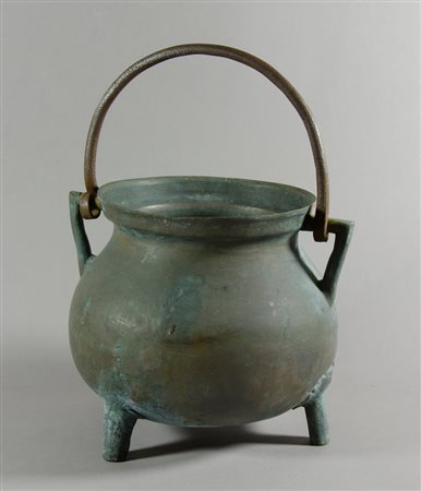 Bronzino poggiante su tre piedi, con manico.