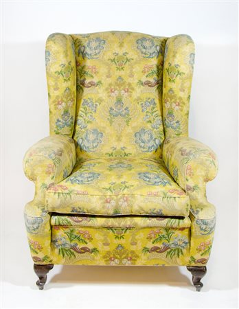 Poltrona ad orecchie rivestita con stoffa floreale.