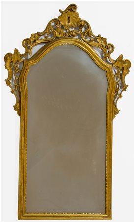 Specchio con cornice sagomata in legno dorato. cm. 131x74.