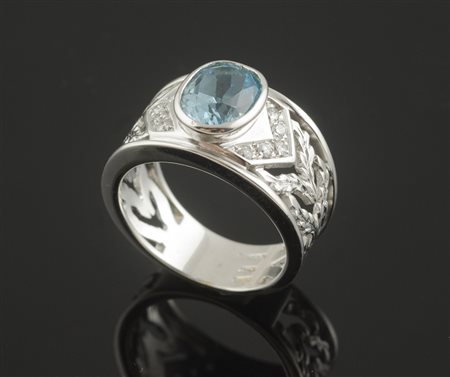 Anello in oro bianco a fascia traforata con brillantini centrato da topazio...