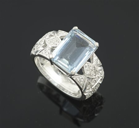 Anello in oro bianco a fascia traforata con brillantini centrato da...