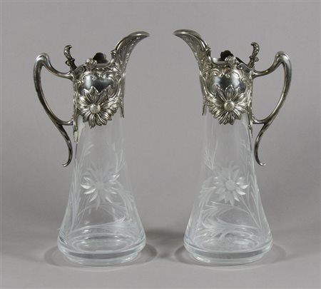 Coppia di brocche in cristallo inciso con montatura in metallo sbalzato e...